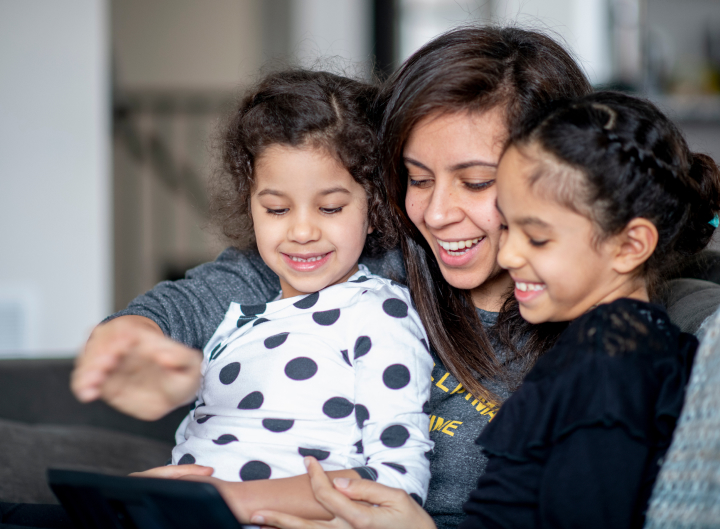 Mum and daughters watch screens together, getting close can help with iPad tantrums