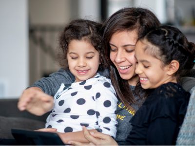 Mum and daughters watch screens together, getting close can help with iPad tantrums